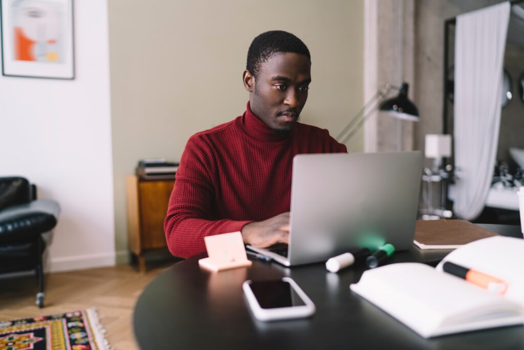 Focused African American freelancer working on laptop