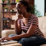 Serious thoughtful freelancer working, looking at laptop